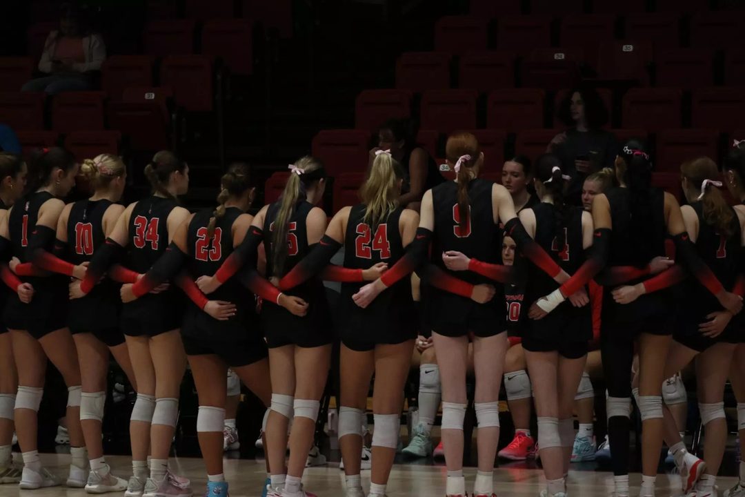 Carthage women's volleyball team in a huddle
