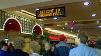 Crowd beneath a Welcome to Oakwood Mall sign in the mall cafe court in Eau Claire in 1986
