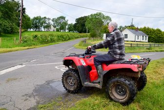 A rider on an all-terrain vehicle on a rural road.