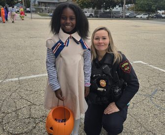 Officer Tanya Watkins with a student at Frank Elementary trunk-or-treat