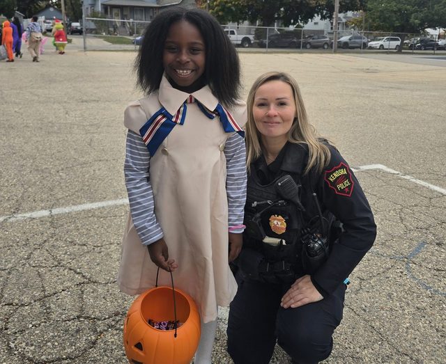 Officer Tanya Watkins with a student at Frank Elementary trunk-or-treat
