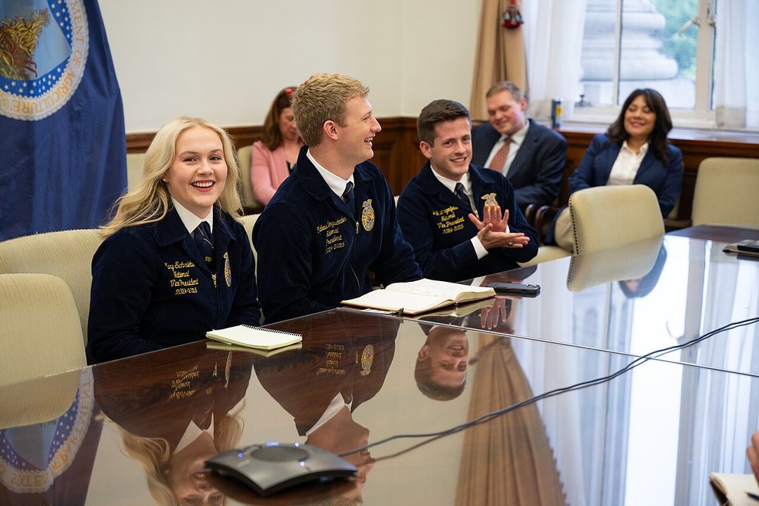 National FFA officers in their blue jackets seated at a table during a visit to USDA headquarters in Washington, D.C.