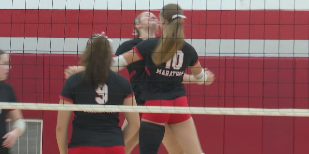 Marathon volleyball players celebrate at the net during their match against Rib Lake