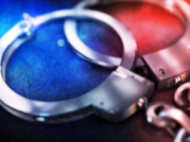 Handcuffs in a close-up photo with blurred red and blue tones