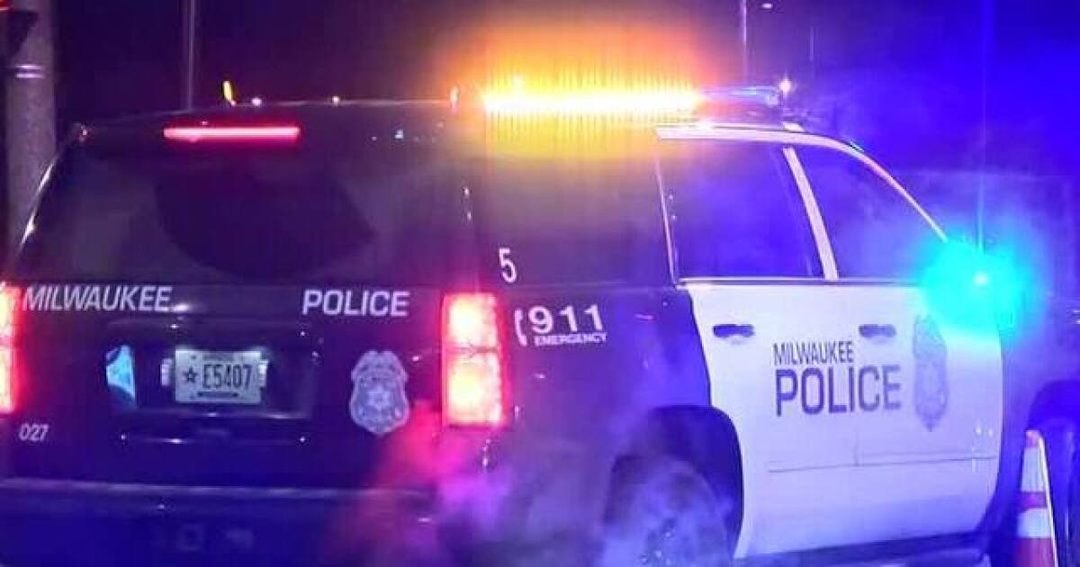 A Milwaukee Police SUV with its emergency lights on at night