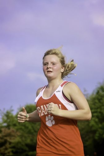 A high school cross country runner racing during a meet